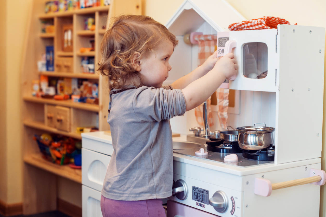 petite fille de 2 ans joue avec une cuisine jouet