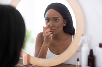 Femme Qui Complexe Sur Son Nez En Se Regardant Dans Le Miroir
