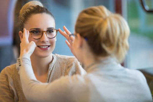 Une vendeuse aide une femme à choisir sa monture de lunettes