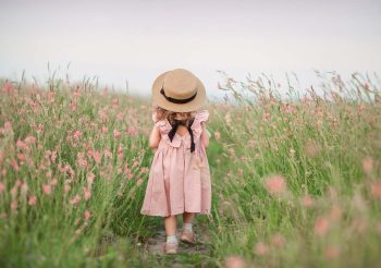 Petite fille dans une belle robe dans un champ fleuri un jour d’été