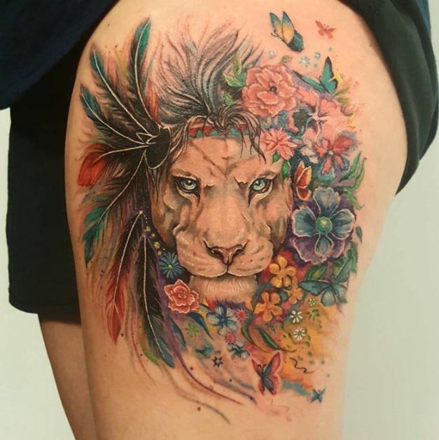 Tatouage Lion Avec Fleurs, Plumes Et Papillons Colorés Sur La Cuisse 
