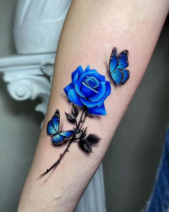Tatouage Rose Et Papillons Bleus Sur L'avant Bras 