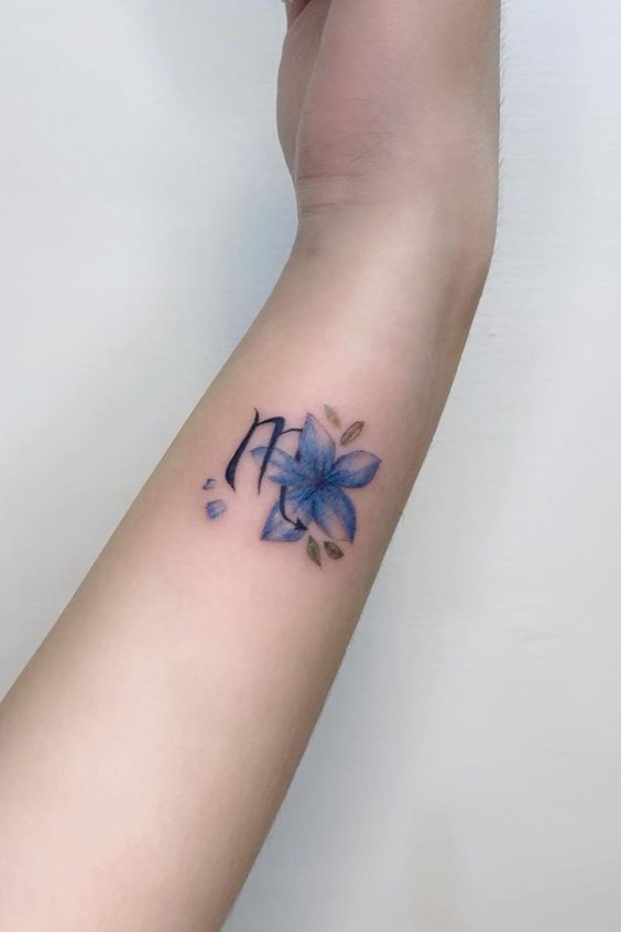 Tatouage Signe Scorpion Et Fleur Bleue Sur L'avant Bras 