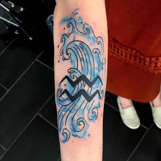 Tatouage Signe Verseau Et Vague En Aquarelle Bleue Sur L'avant Bras 