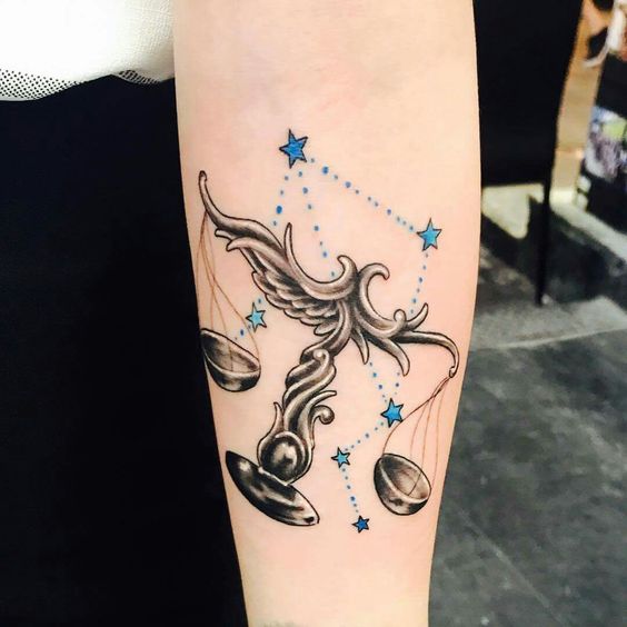 Tatouage Balance En Noir Et Gris Avec Constellation Bleue Sur L'avant Bras 
