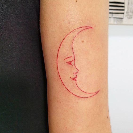Tatouage Lune Rouge Avec Visage Sur Le Bras 