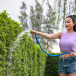 Active Young Woman Watering Hedge In Garden With H 2024 03 08 17 26 35 Utc