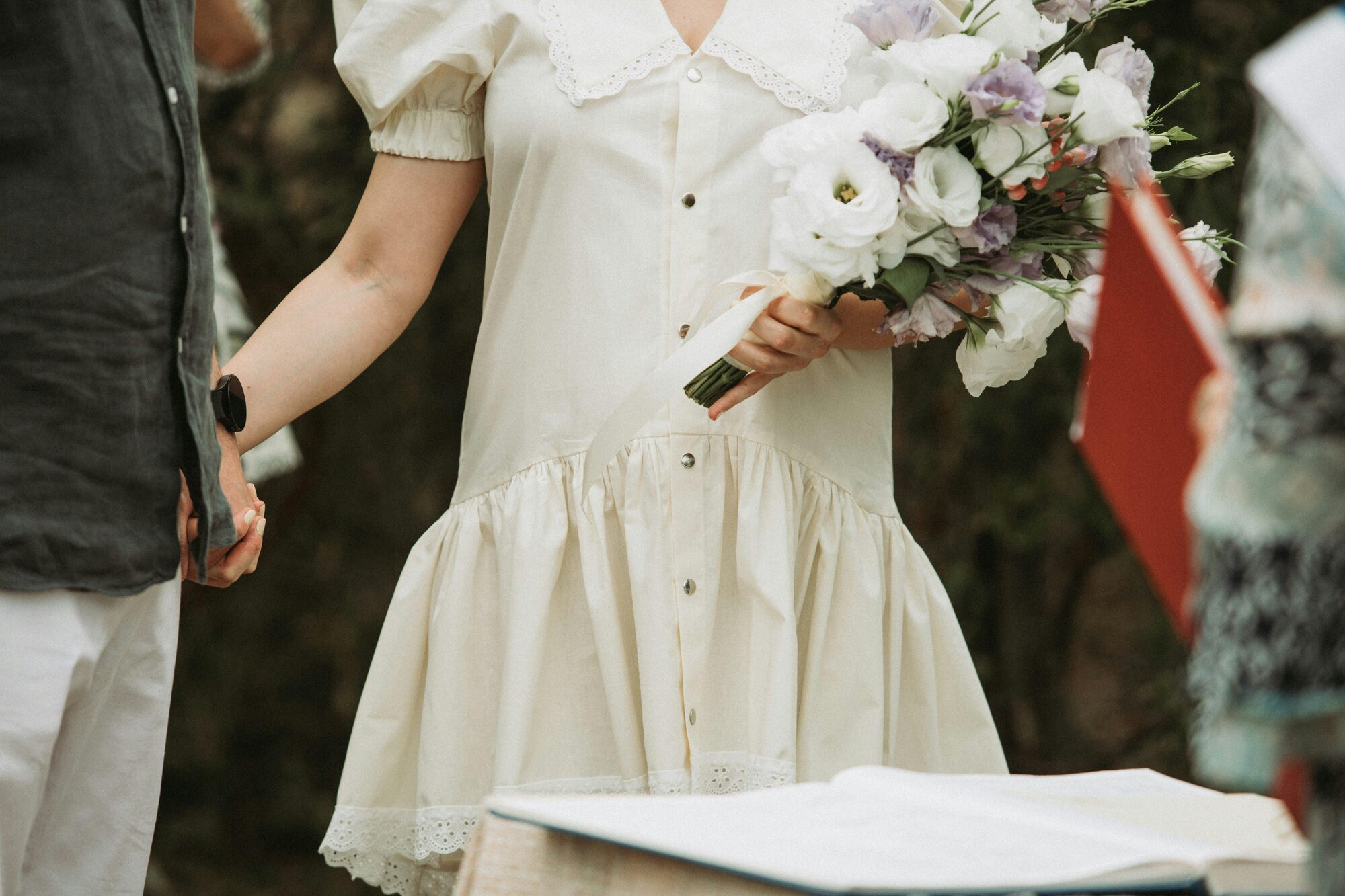 A Woman In A White Dress Holding A Bouqu